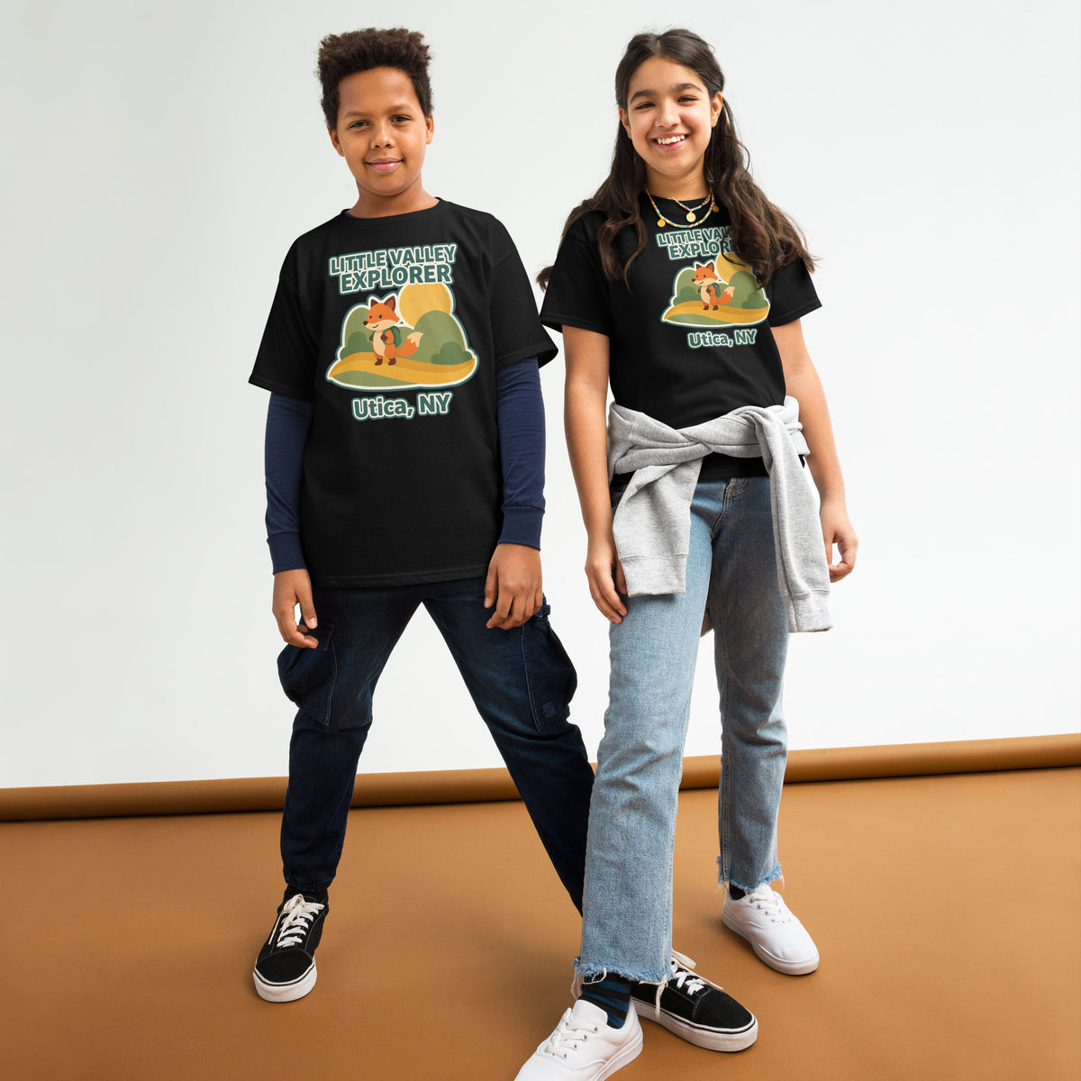 Two models wearing black youth T-shirts with Little Valley Explorer fox graphic and Utica, NY lettering